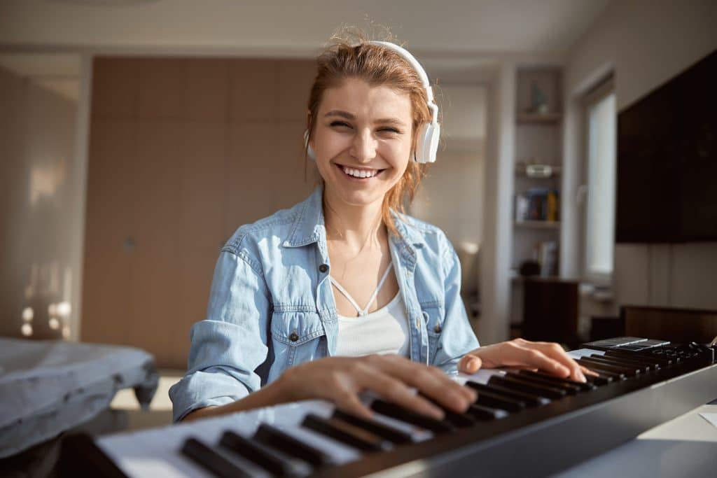 Cheerful brunette keeping smile on her face while looking straight at camera