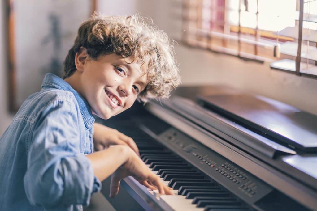 Portrait of smiling boy playing piano at home