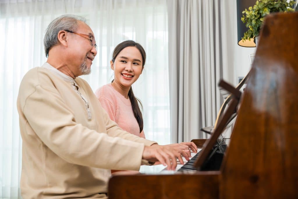 Young woman teaching piano for senior man teaching