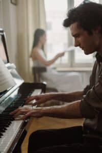 Man playing piano at home, focused and relaxed